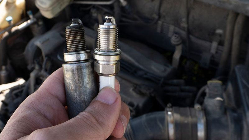 Close-up of worn spark plugs, a common cause of the P0300 code (random misfire) problem.