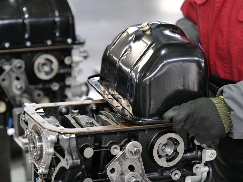 Mechanic assembling an engine on the auto engine production line at Nanjing Woda Auto Technology Co., Ltd.