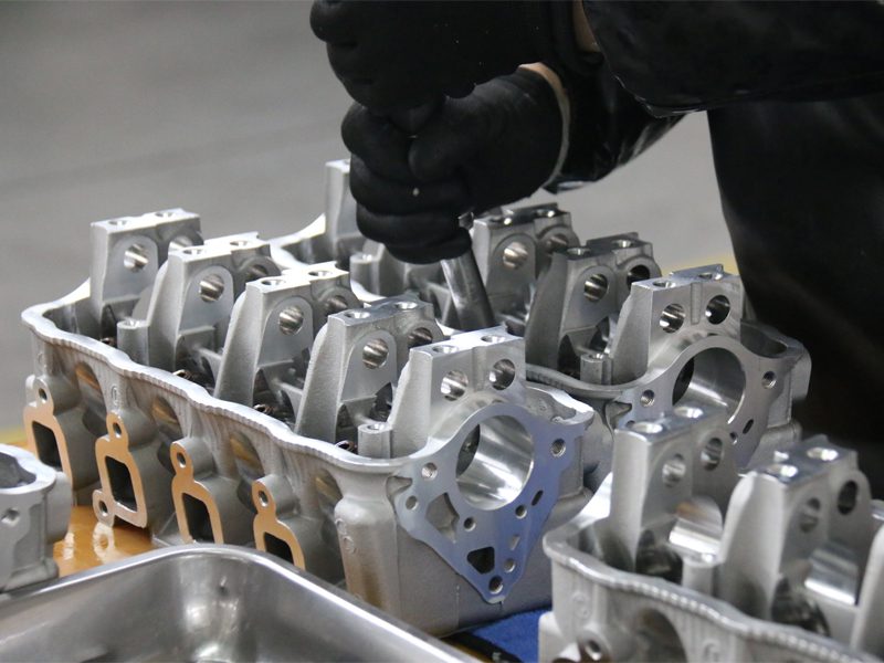 Auto engine factory at Nanjing Woda Auto Technology Co., Ltd., assembling the cylinder head with precision and care.