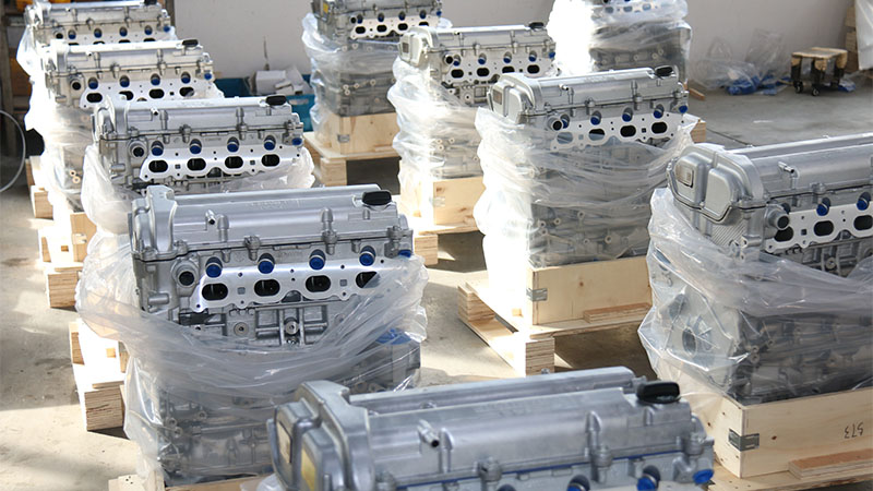 Newly manufactured aluminum engine blocks arranged in rows at a factory.