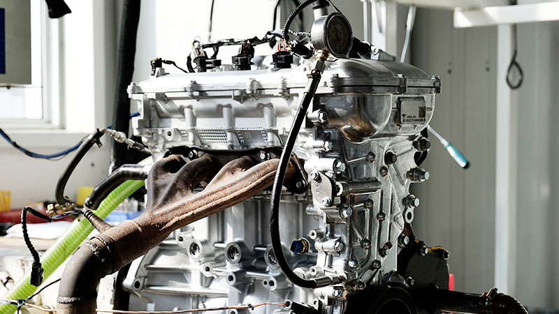 Automotive engine mounted on equipment at an engine assembly or testing station.