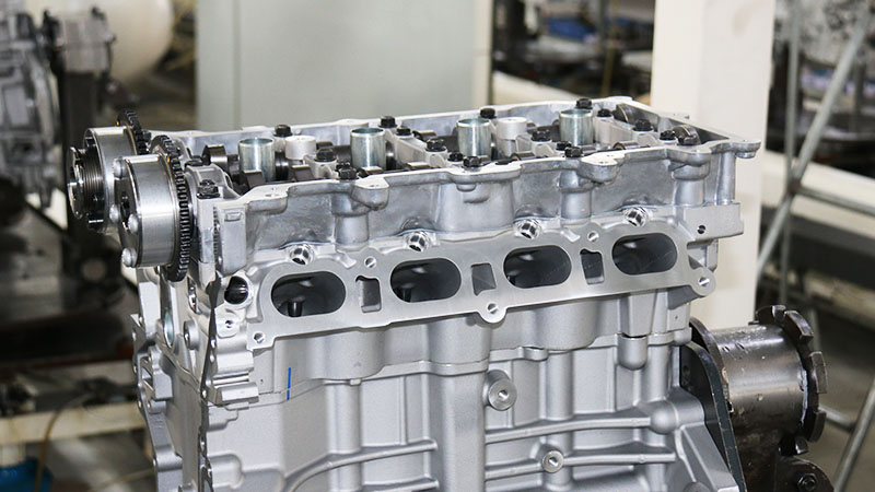 Close-up of a newly assembled aluminum automotive engine at a production workstation.