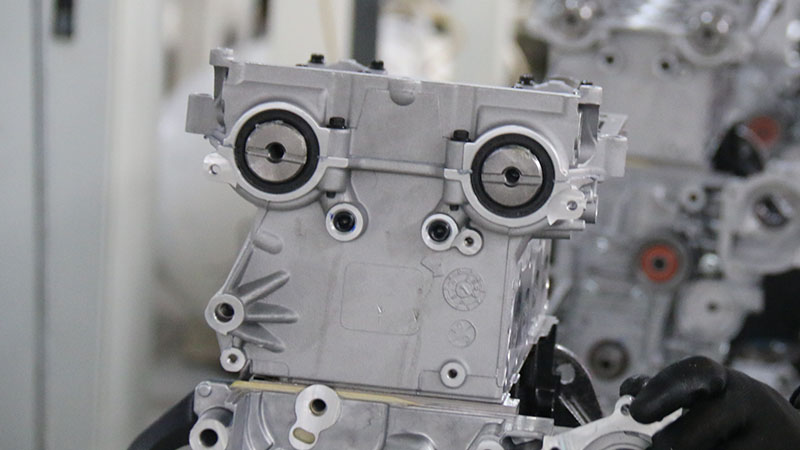 Close-up of the front of an aluminum engine assembly showing machined openings and mounting points.