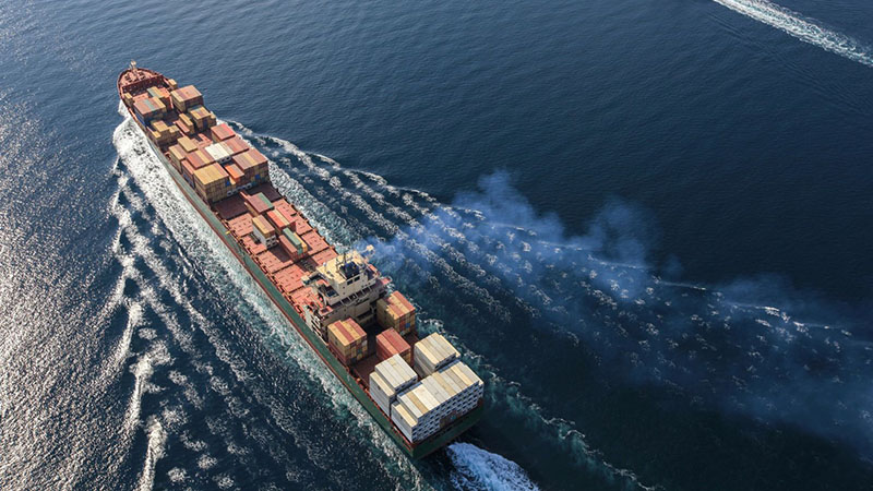 Cargo ship on the sea, representing international shipping and the global supply chain for auto engine parts.