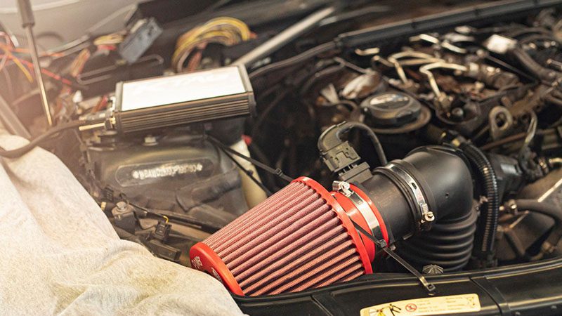 Close-up of a new air filter installed on a car engine after a complete tune-up.