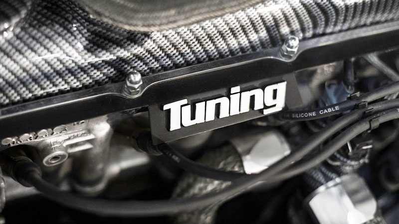 Close-up of a car engine undergoing a tune-up during maintenance in a workshop.