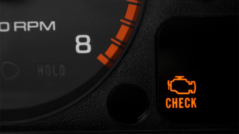 Flashing check engine light on a car dashboard indicating the need for an engine tune-up.