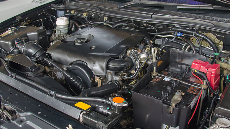 Close-up detail of a car engine showing mechanical components and wiring.