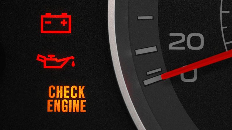 Close-up of a car dashboard with the check engine light flashing, indicating a potential issue with the engine.
