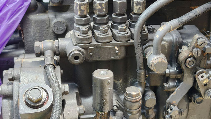 Fuel injection pump assembly with fuel lines and internal check valve components on engine.