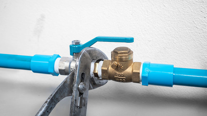 Brass check valve installed in a water pipe system.