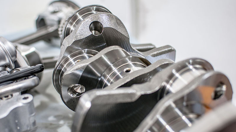 Close-up of engine crankshaft showing journal and counterweight details.