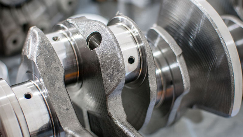 Close-up view of a crankshaft with finished journal surfaces for engine durability.