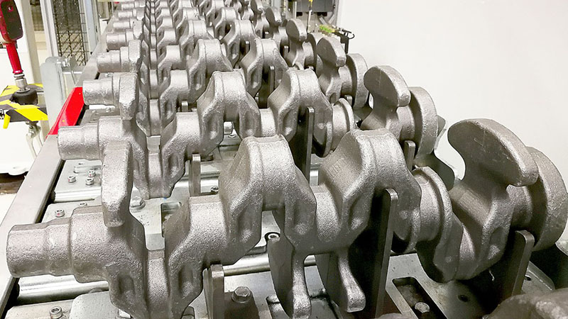 Crankshaft blanks arranged at an automotive parts manufacturing facility for machining and further processing.