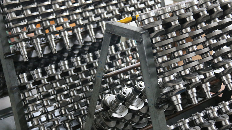 New automotive engine crankshafts displayed on Woda Auto's factory production line, showcasing replacement engine parts for wholesale supply.