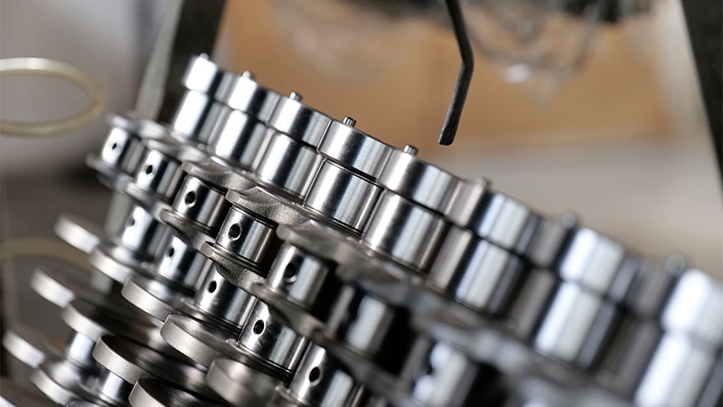 New automotive engine crankshafts being cleaned and prepared for assembly at a manufacturing facility.