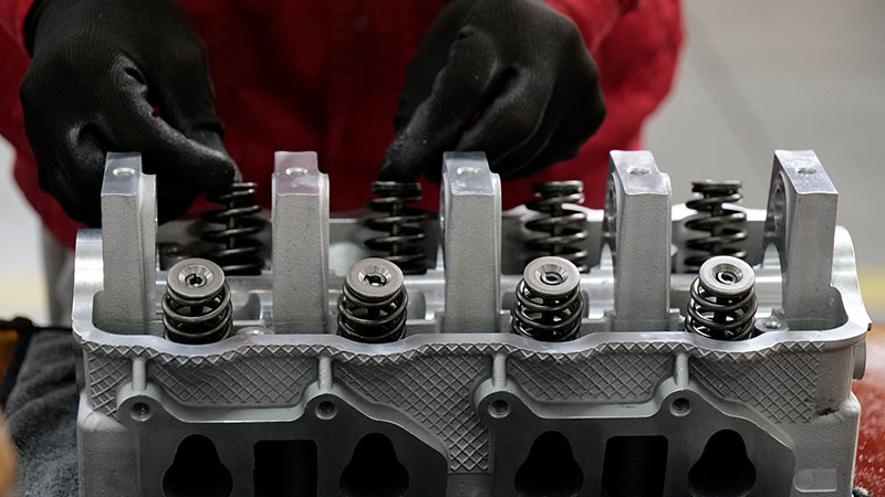Mechanic installing valves on cylinder head.