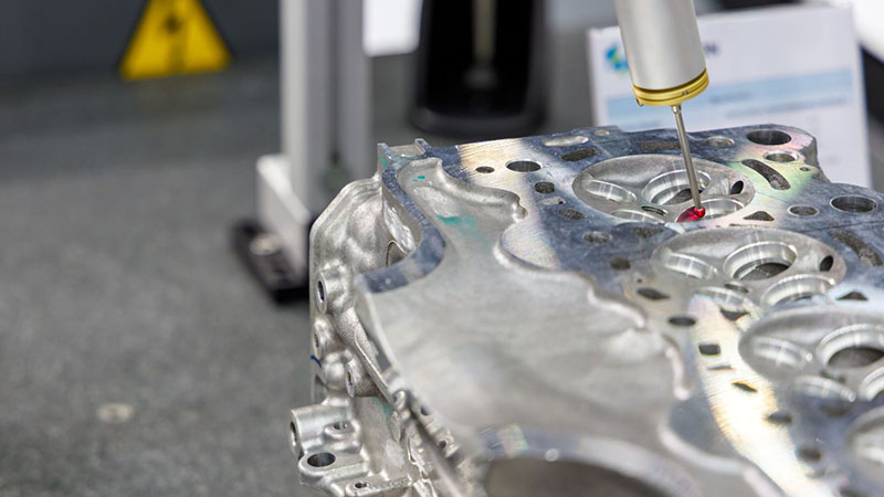 Close-up inspection of aluminum automotive cylinder head dimensions.