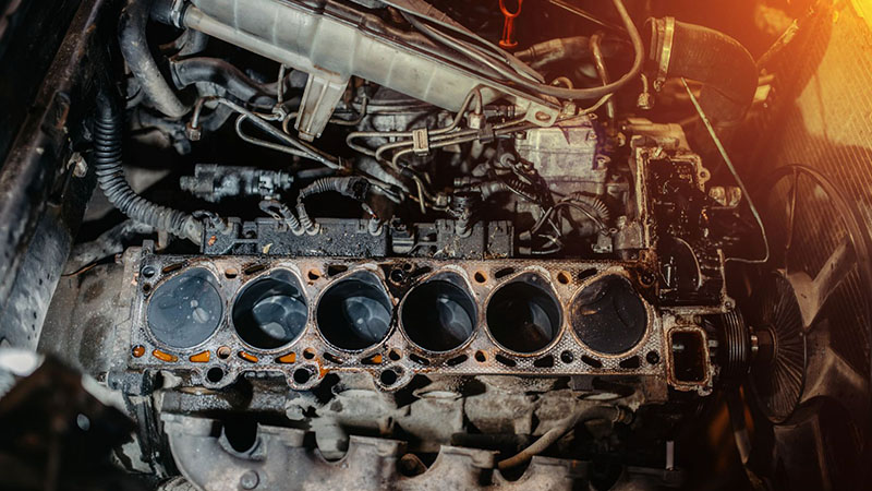 Engine repair showing cylinder head diagnostics and damaged cylinder block gasket.