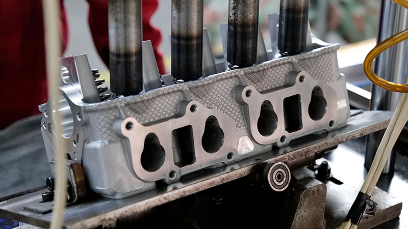 Cylinder head assembly process using professional equipment in an automotive factory.