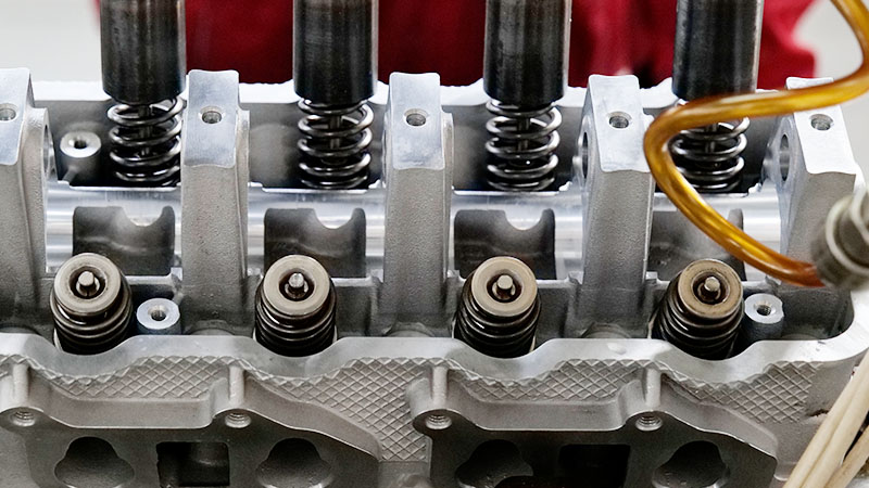 Close-up view of a cylinder head during automotive assembly production.