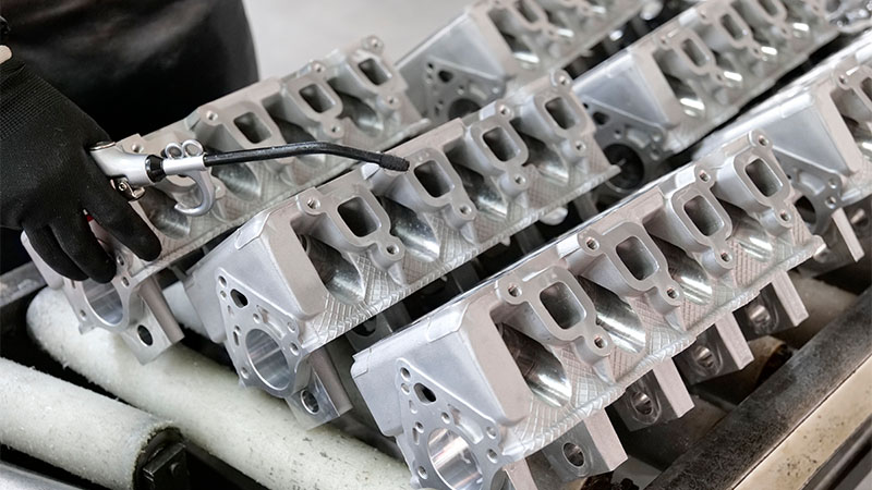 Cylinder heads being cleaned during automotive engine parts processing.