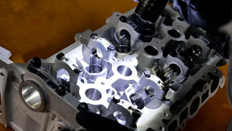Technician inspecting a cylinder head during quality control.