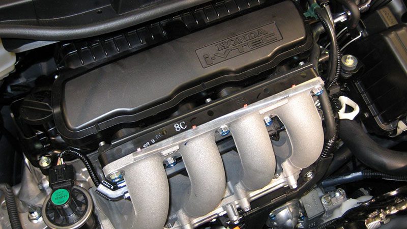 Close-up of a Honda L15A 1.5L SOHC i-VTEC engine in a 2007 Honda Fit RS, showcasing single overhead camshaft design with variable valve timing.