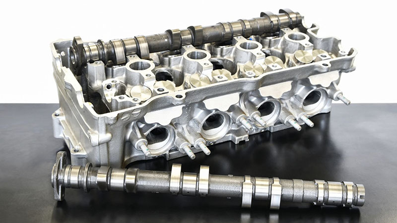 Close-up view of an engine cylinder head showing valves and combustion chambers.