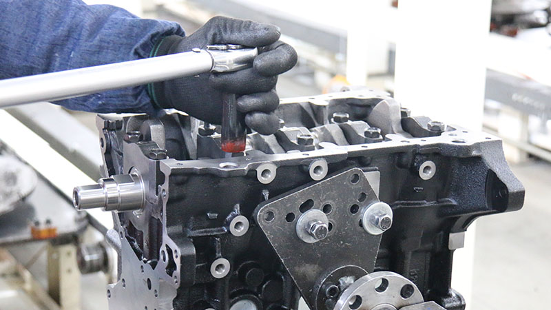 Mechanic working on automotive engine repair in workshop.