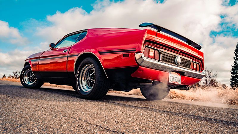 Red Chevrolet camaro on road during daytime.