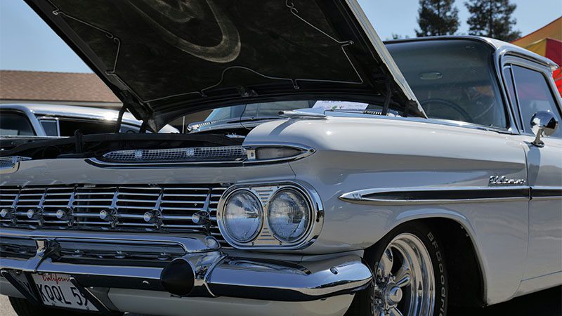 A classic American land yacht with the hood opened.