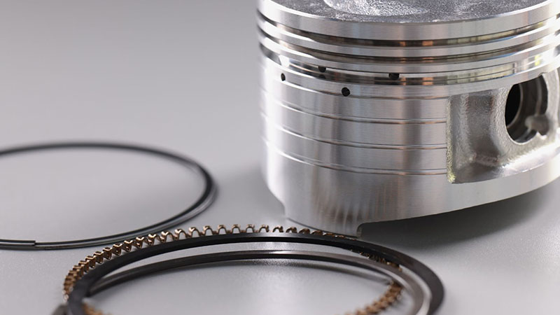 High quality spare engine piston and piston rings for automotive repair and maintenance.
