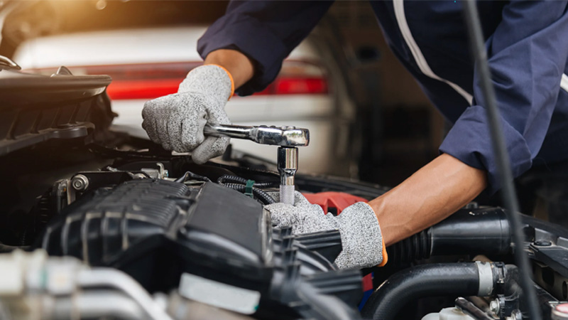 Mechanic repairing a car engine during auto maintenance service.