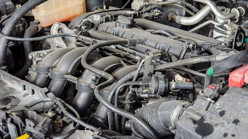 Close-up view of a car engine showing mechanical components and details relevant to replacement engine compatibility.