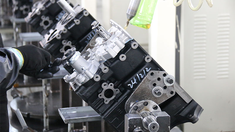 Automotive engine assembly on a factory production line, showing the manufacturing process of replacement engines.