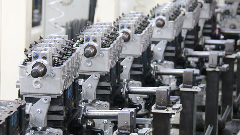 Automotive engine assembly line at Woda Auto's factory, showing replacement engines being assembled during production.