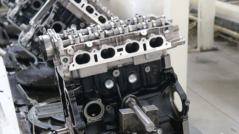 Close-up view of a long block engine assembly showing the cylinder head, engine block, and mechanical components.
