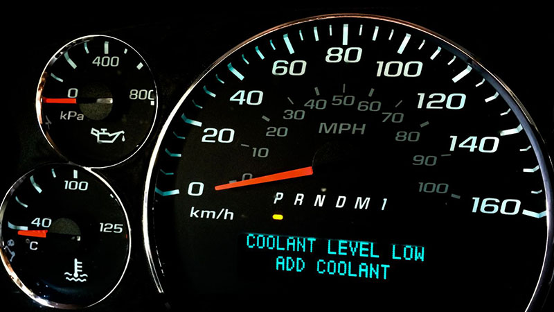 Coolant level low warning light illuminated on a vehicle dashboard, indicating the need for coolant maintenance.