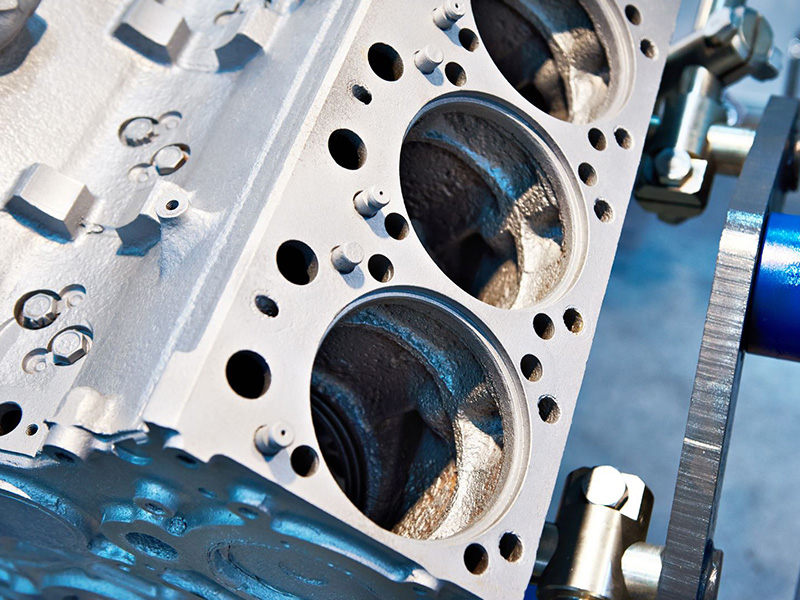 Close-up of engine cylinder block on a workbench during development inspection.