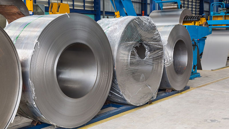 Cold rolled steel coils stored in a manufacturing area ready for metalworking production.