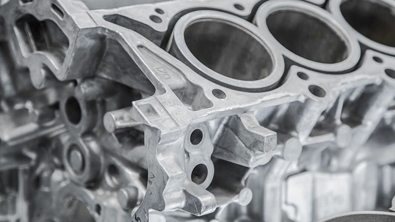 Close-up of a car engine block on a workshop bench.