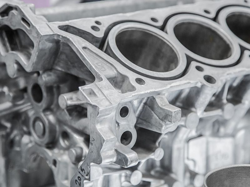 Close-up of a new car engine block showcasing its cylinders and casting details.