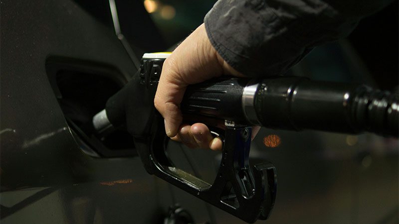 Refueling a fuel-powered vehicle at a gas station.