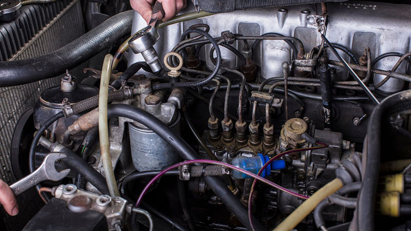 Car engine repair in progress with exposed engine components.