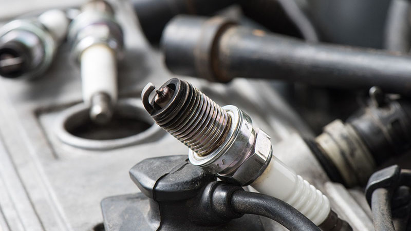 Close-up of worn spark plugs causing engine hesitation during acceleration.
