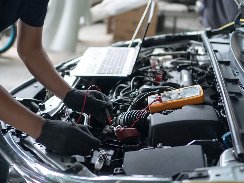 Professional car mechanic diagnosing an engine misfire, inspecting components to identify the cause.