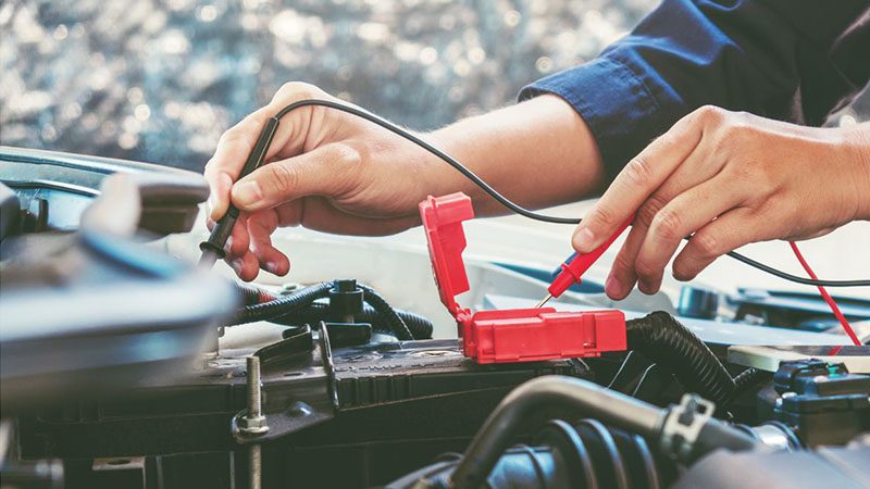Mechanic working in an auto repair service shop, inspecting and repairing vehicle components to fix engine misfires.