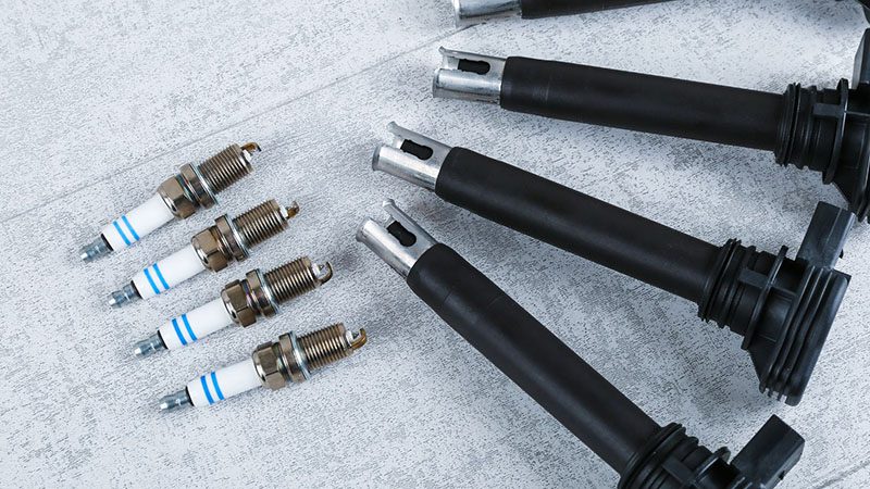 Top view of brand new spark plugs and ignition coils, essential components for preventing engine misfires.