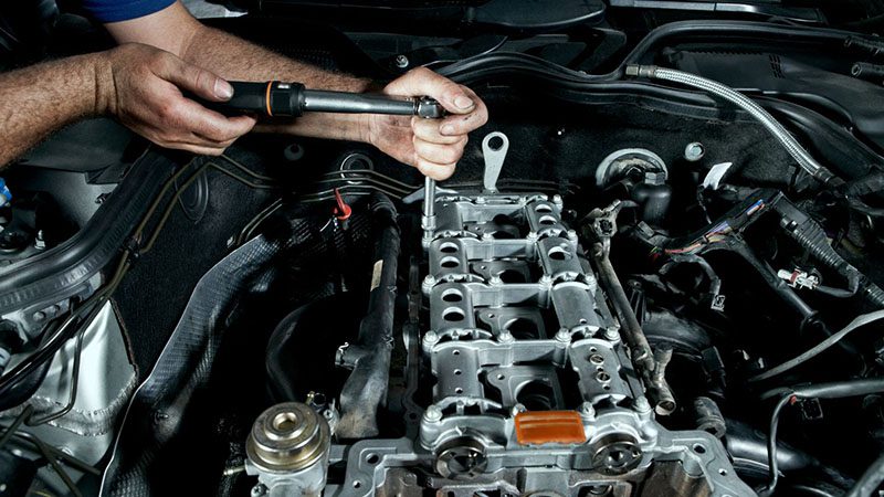 Repairman working on a car in an auto repair shop.